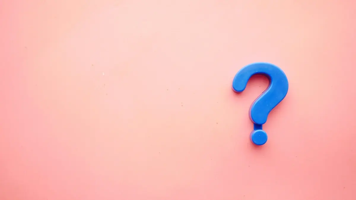 a blue question mark on a pink background