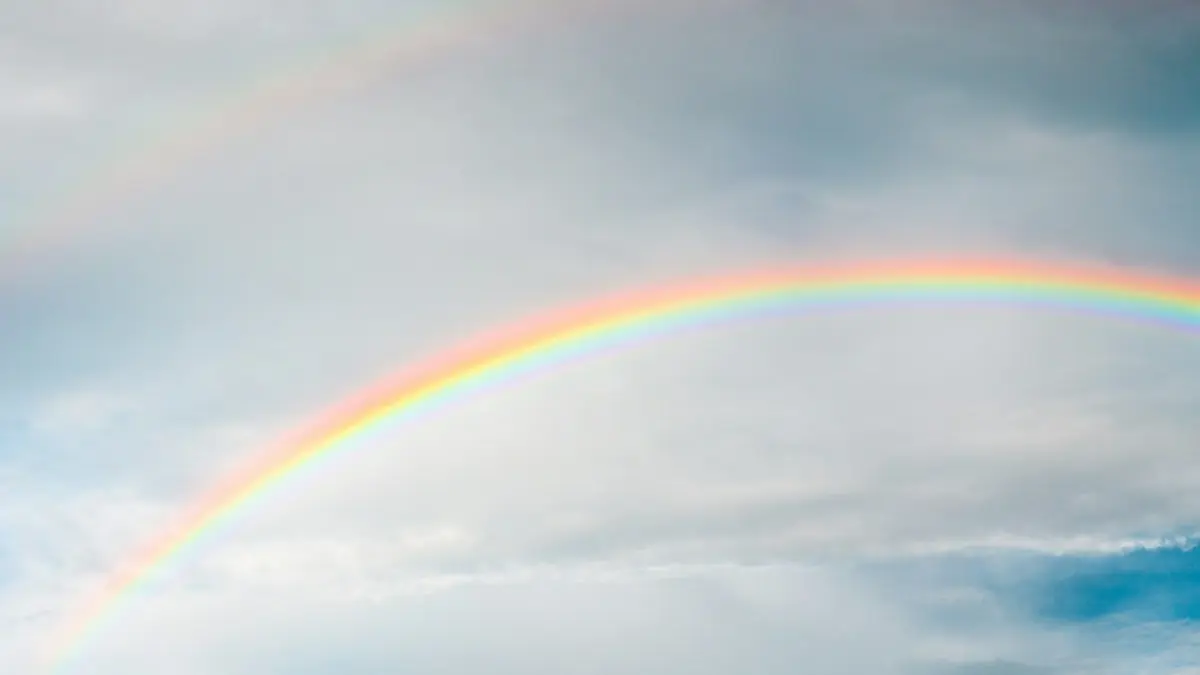 rainbow under cloudy sky during daytime