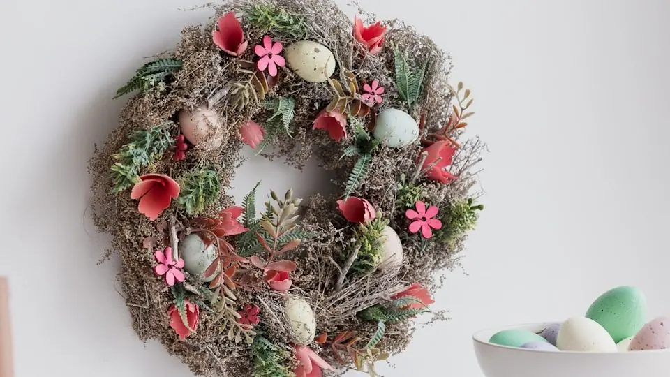 a wreath hanging on a wall next to a bowl of eggs
