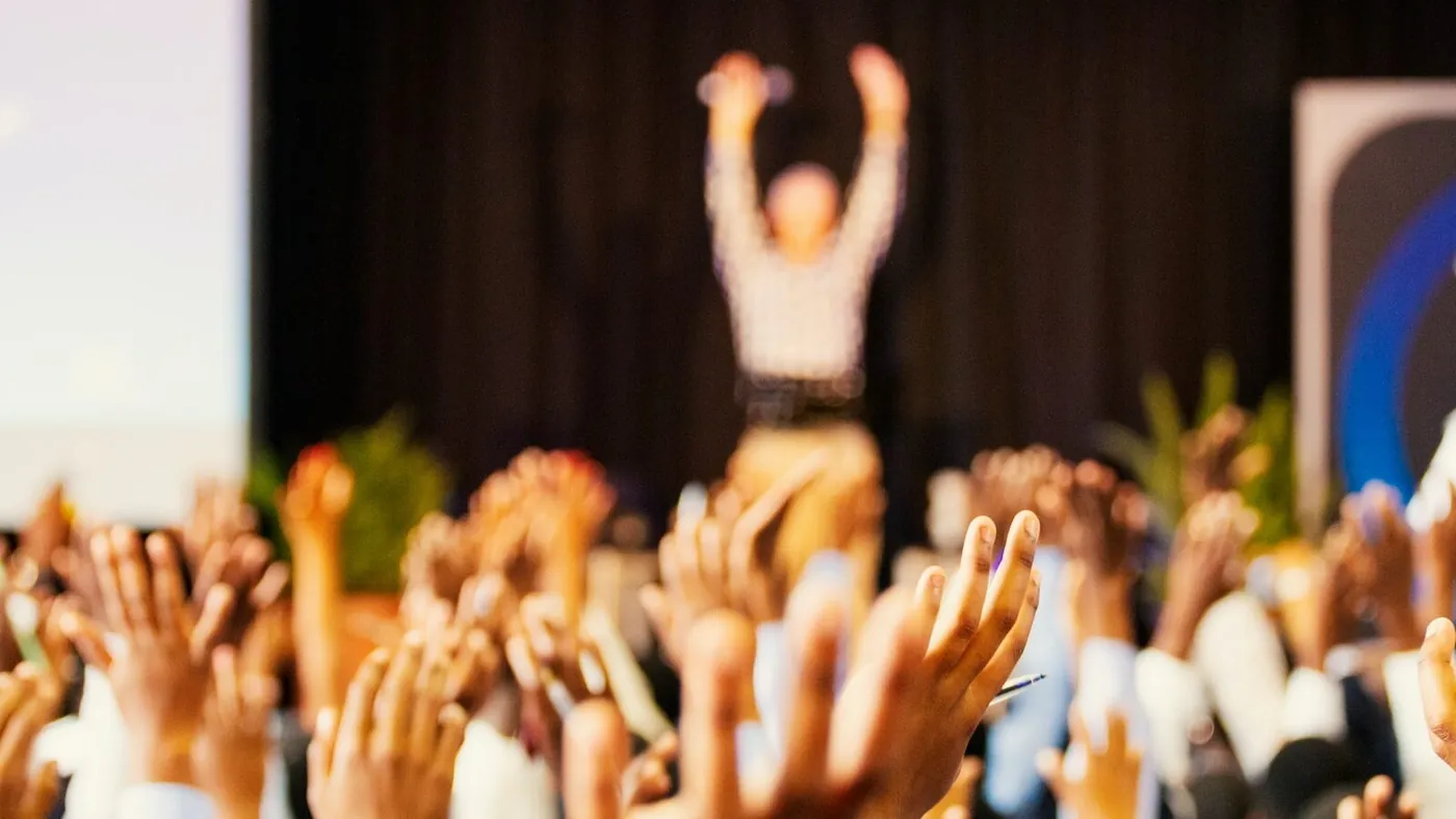 people raising hands with bokeh lights