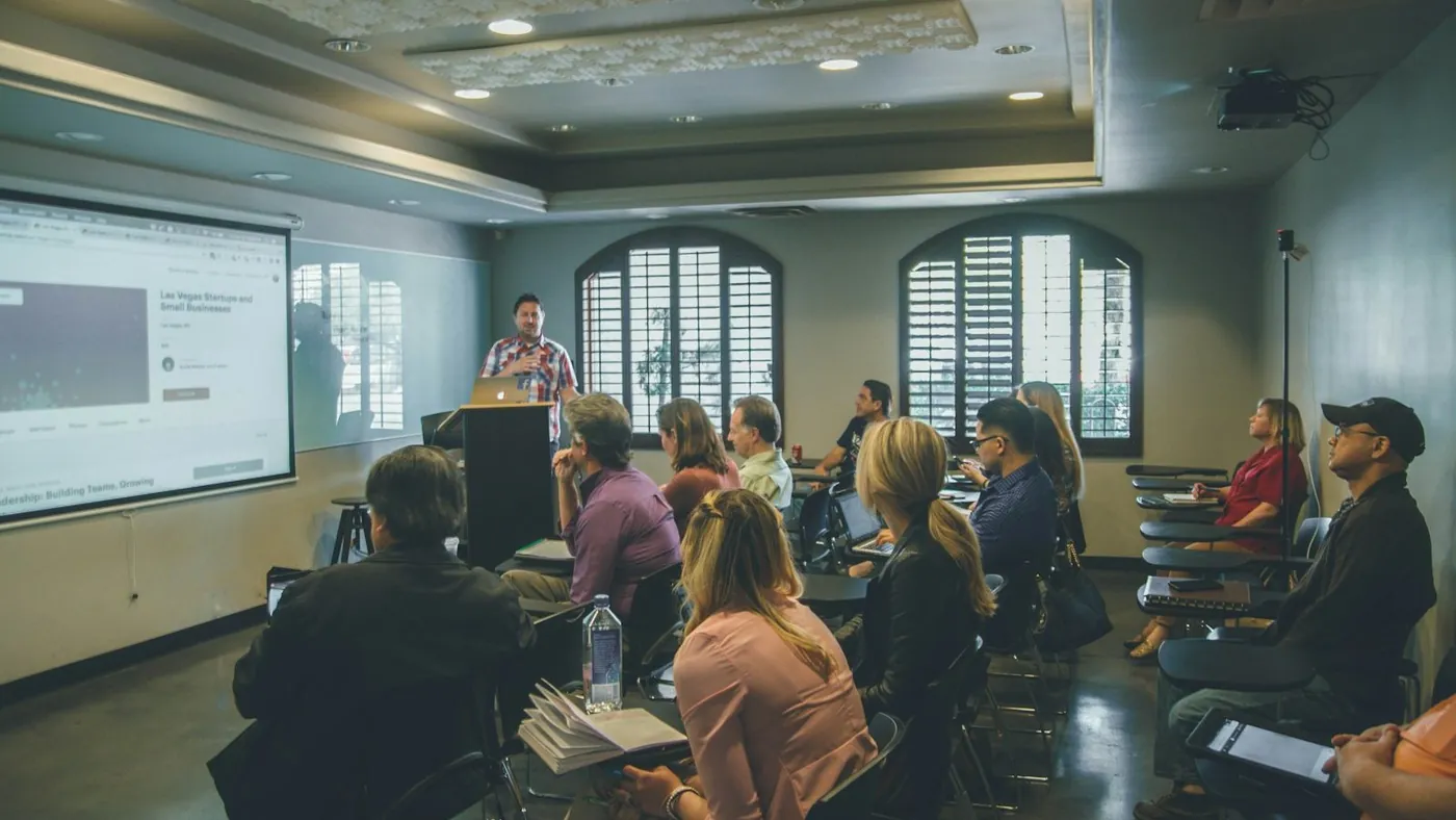 a group of people in a room with a projector screen