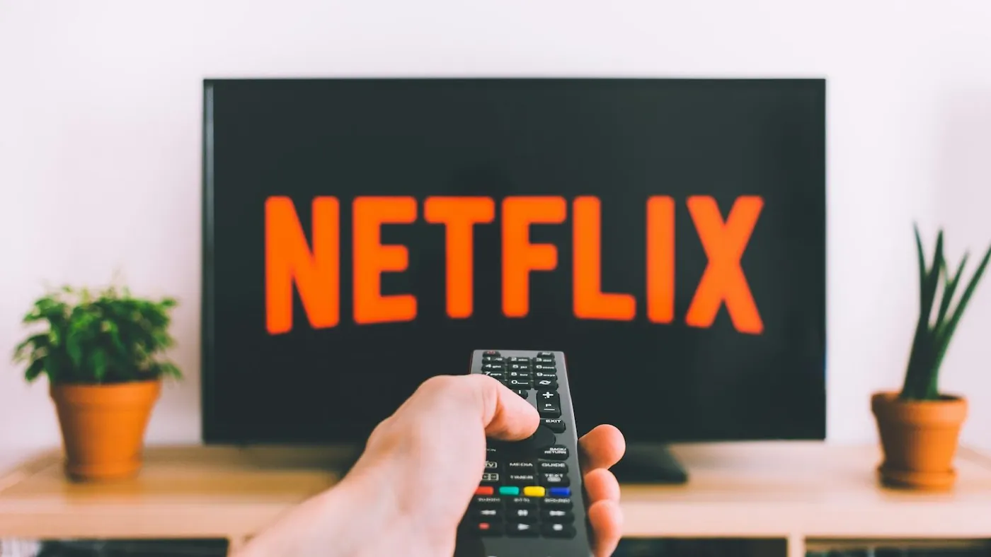 person holding remote pointing at TV