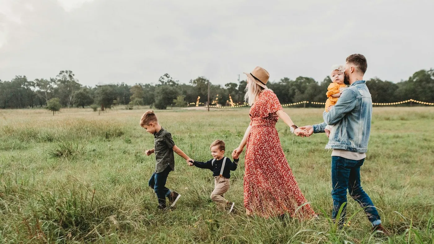 woman holding man and toddler hands during daytime