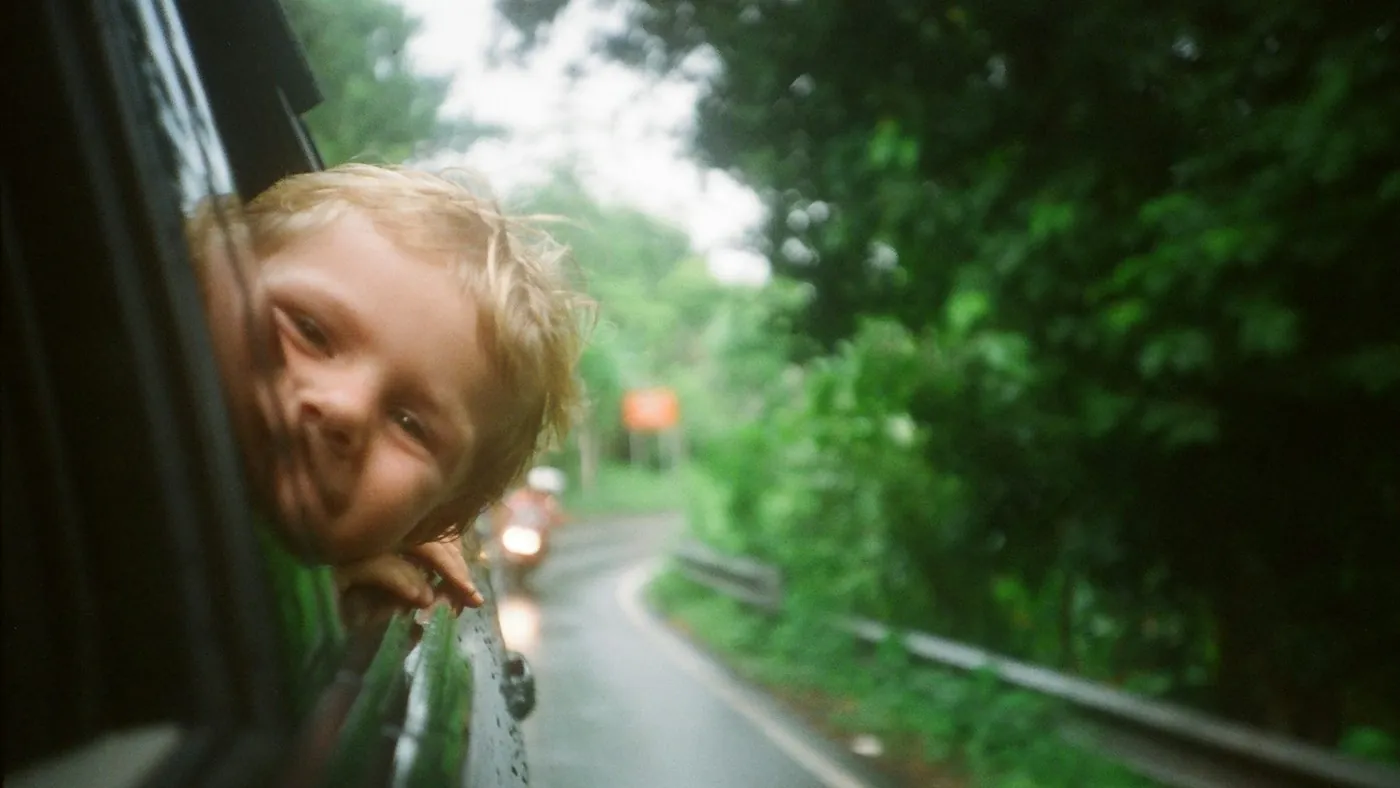 child peeking from vehicle window