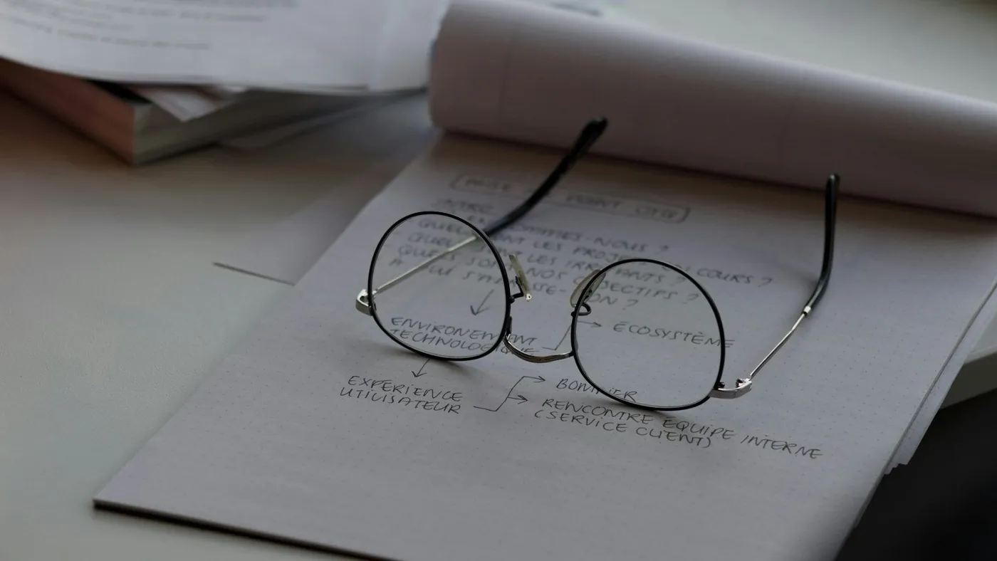 black framed eyeglasses on top of white printing paper