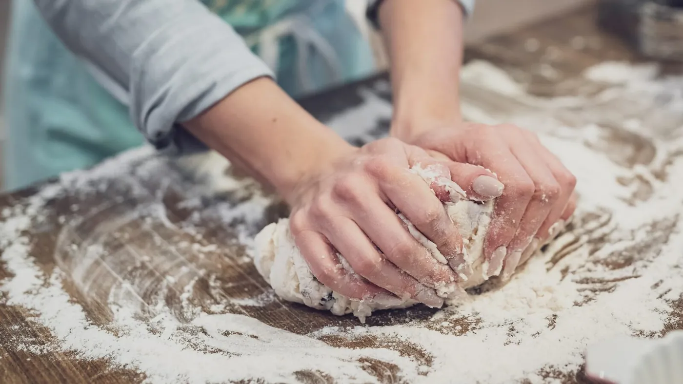 person standing and making dough