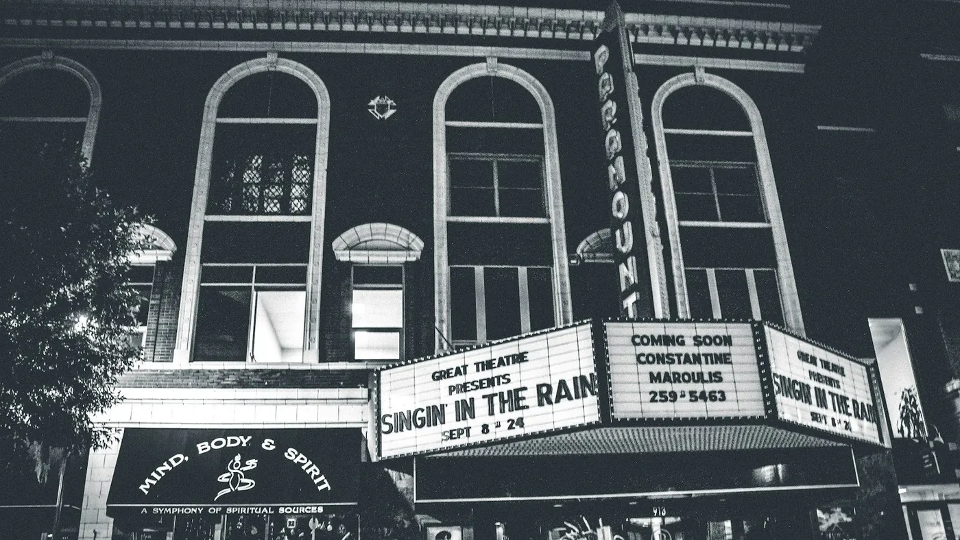 grayscale photo of theater hall with Singin in the Rain movie