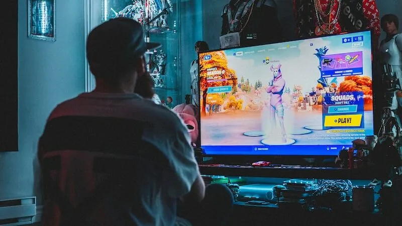 man in red shirt watching tv
