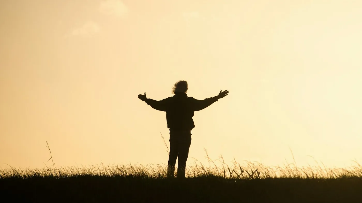 silhouette of person spreading hands