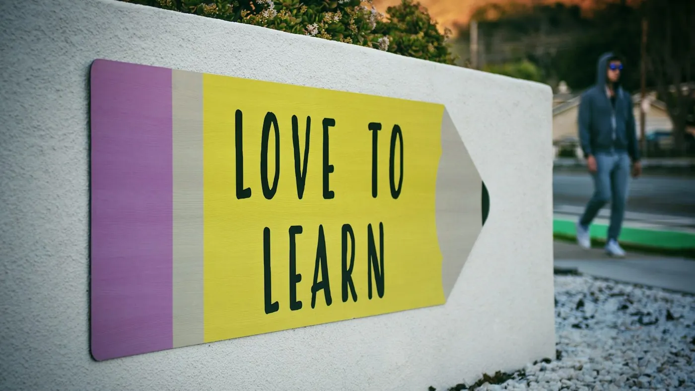 love to learn pencil signage on wall near walking man